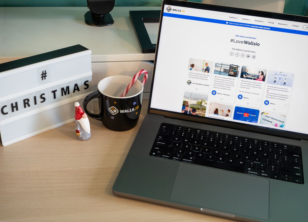 Un bureau chaleureux décoré pour Noël, avec une tasse et l’écran d’un ordinateur portable affichant un site web.